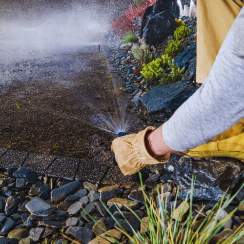 CitiLawns technician performing sprinkler system inspection in Redding